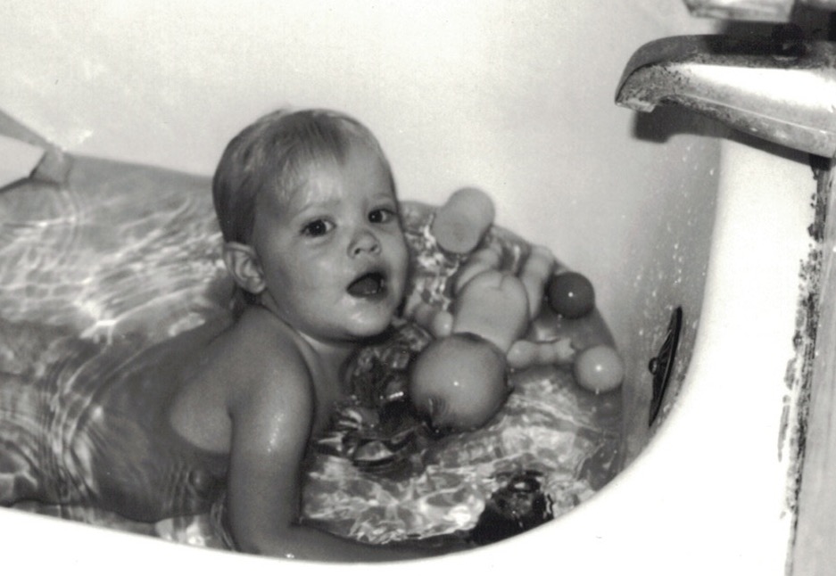 black and white photo of young jennifer as a child playing in the tub