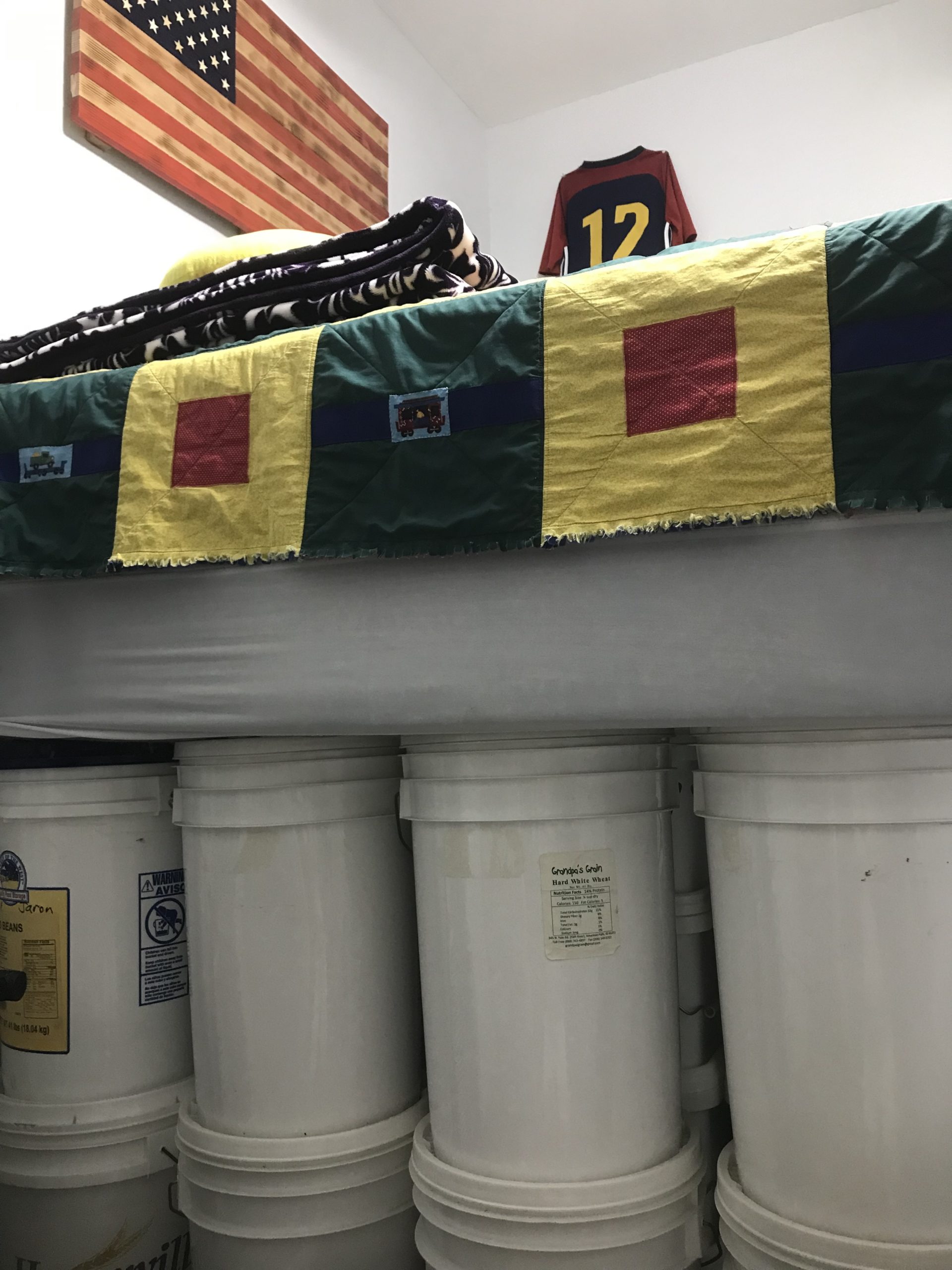 five gallon buckets of food storage under a bed